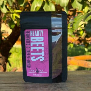 A package of Hearty Beets Fermented and Freeze-Dried Powder displayed on a piece of wood with a natural background